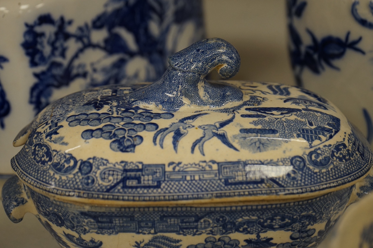 A group of blue and white ceramics to include Ironstone cheese dome and jug, a basin and twin handled cups, largest 36cm in diameter. Condition - varies